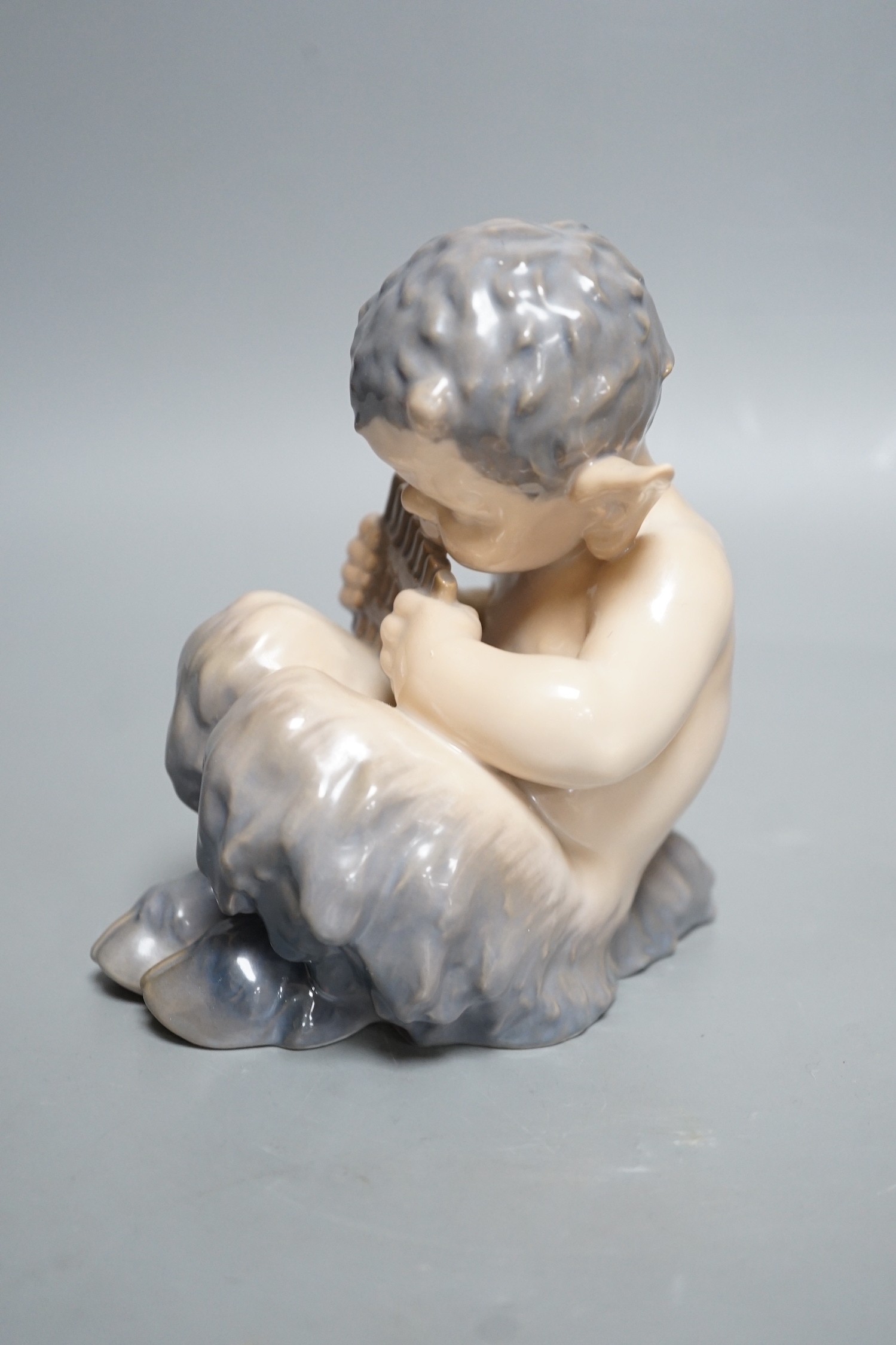 A Royal Copenhagen porcelain model of a seated faun, number 1736, 13cm tall